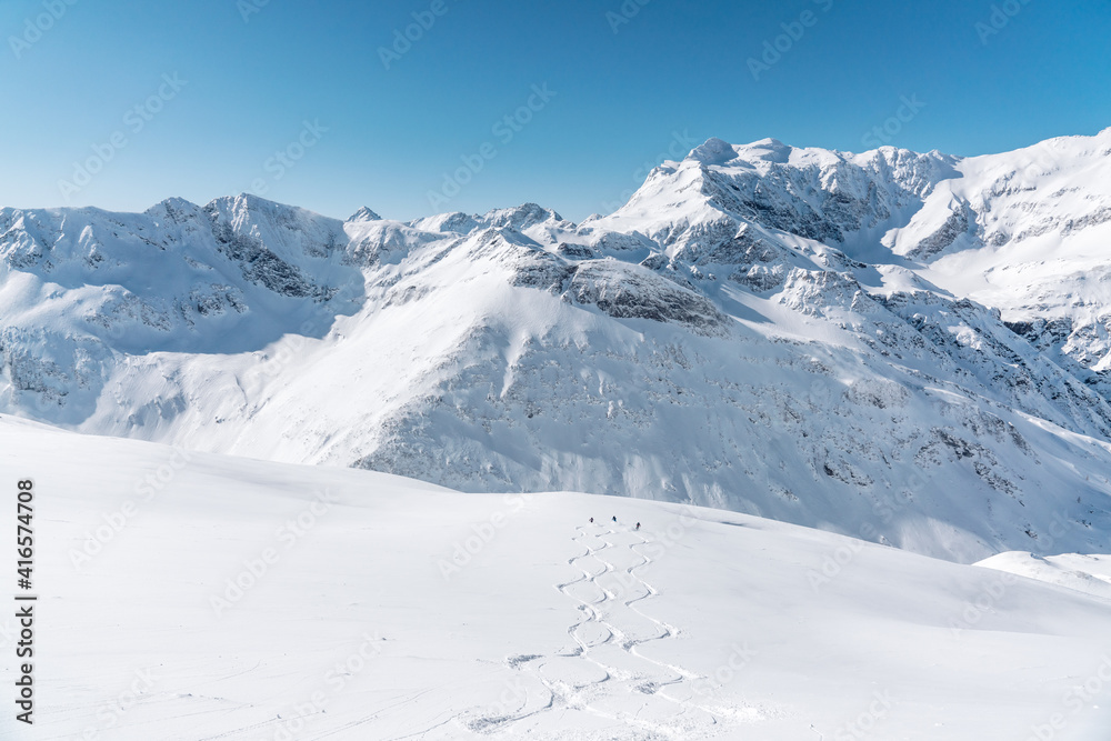 Three skiers do powder skiing in formation down the mountain in Sportgastein, Austria. Three skiers do powder skiing in formation down the mountain in Sportgastein, Austria.