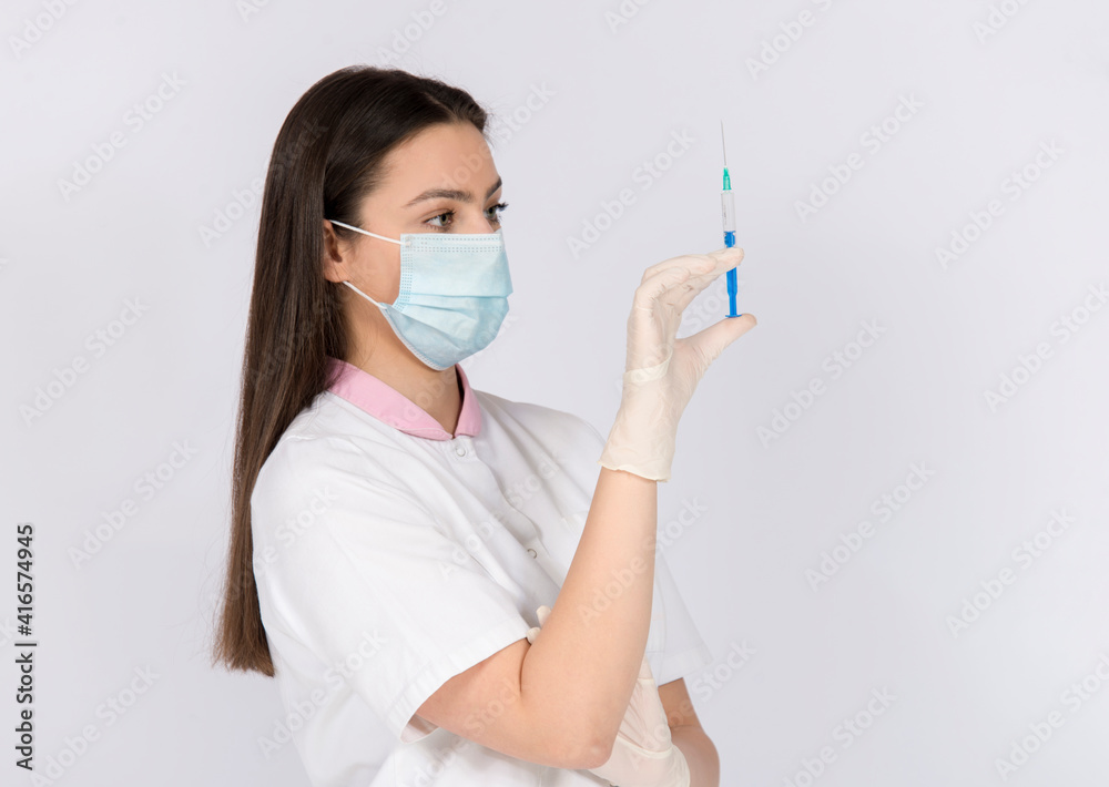 Woman holding vaccine syringe, wearing face mask and gloves, vaccine against corona virus covid 19, time of pandemic Woman holding vaccine syringe, wearing face mask and gloves, vaccine against corona virus covid 19, time of pandemic