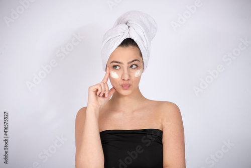 Wallpaper Mural Girl model with face cream under her eyes, concept of skin care and skin products, on white background with copy space Torontodigital.ca