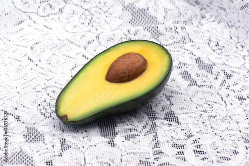 Avocado with a bone on a white tablecloth. Macro