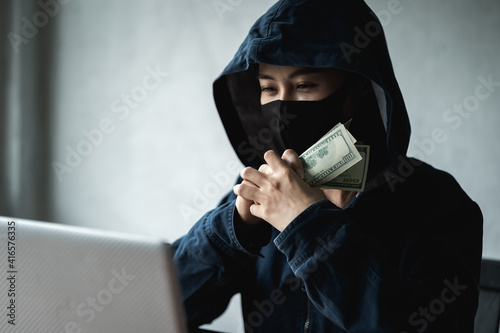 Woman dangerous Hooded Hacker held the money after successfully hacking.