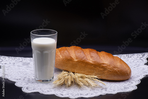 Obraz na płótnie Composition of glass of milk, wheat, white bread on a white tablecloth w salonie