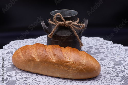 Obraz na płótnie Composition of white bread and old jug on white tablecloth on black background w salonie
