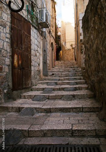 Empty stone paved alley in Old Town Jerusalem, staircase and old buildings