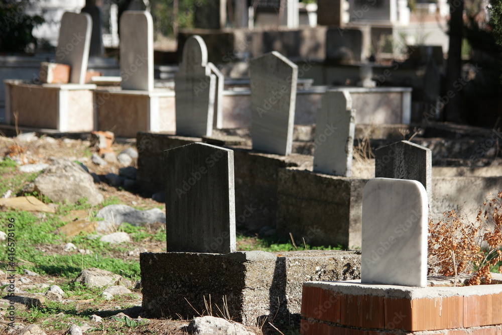 Tombstone and graves in an ancient Muslim graveyard. Islamic headstones and memorials in Turkish graveyard. Muslim cemetery graves. Tombstone and graves in an ancient Muslim graveyard. Islamic headstones and memorials in Turkish graveyard. Muslim cemetery graves.