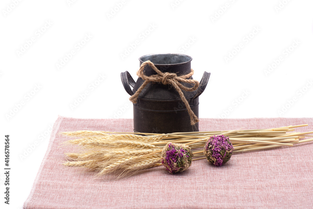 Composition of wheat, antique jug, kitchen towel and dried flowers on white background