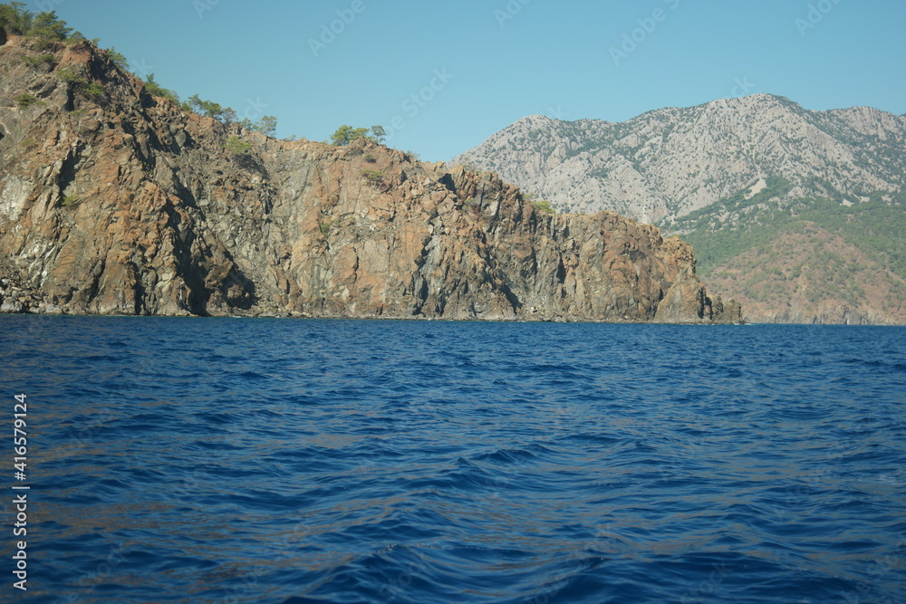 Picturesque view of rocky cliff and blue sea. Beautiful nature background.
