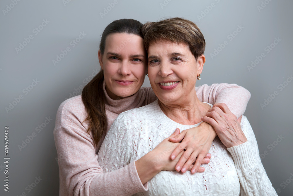 mother and adult daughter smiling looking posing for camera hugging. multi-generational family
mother and adult daughter smiling looking posing for camera hugging. multi-generational family