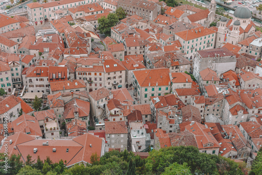Top view on Kotor old town, red roofs and streets with tiles and stone buildings.