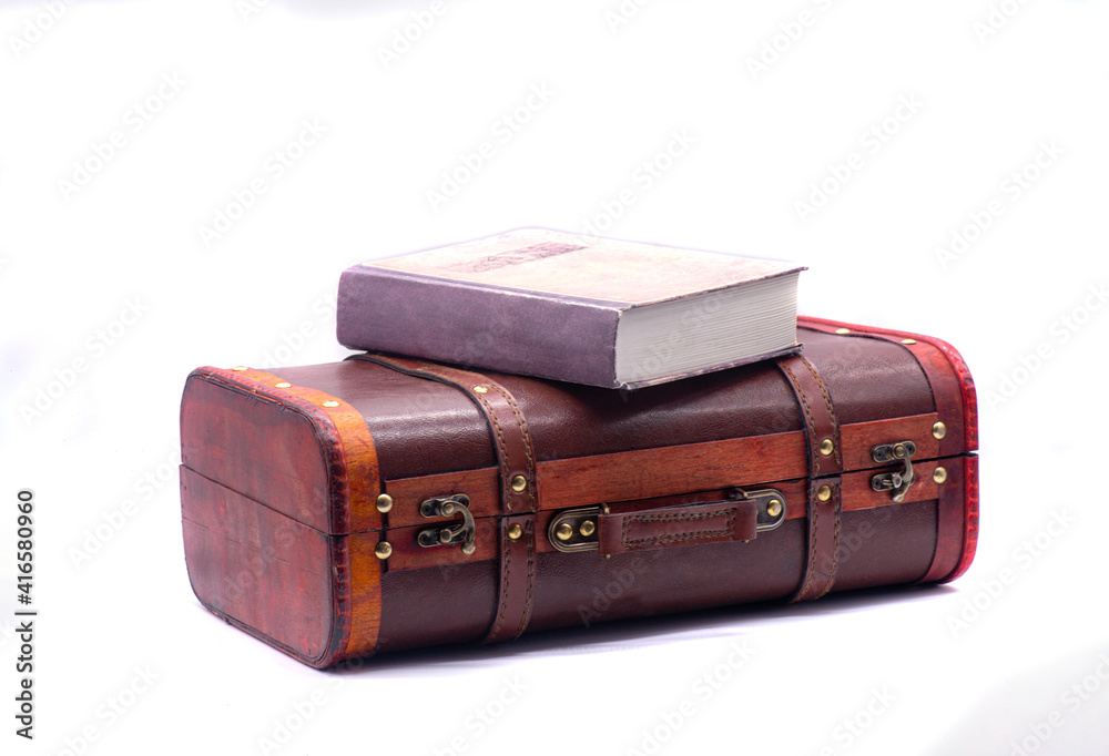 Retro suitcase and book on white background