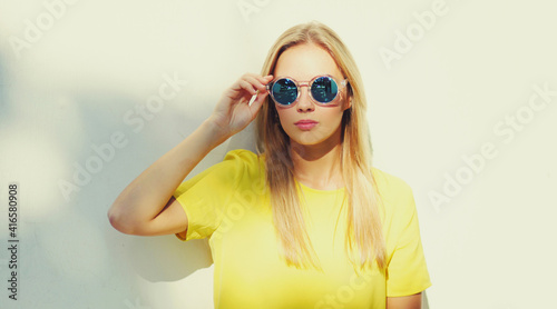 Portrait of stylish blonde young woman posing in a city
