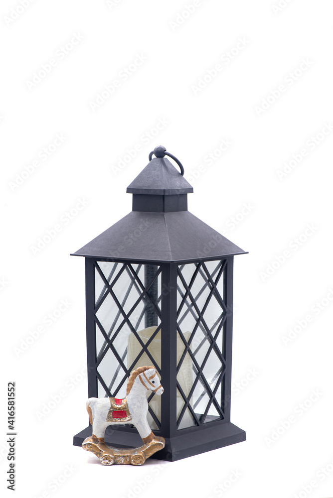 Glass lamp with a candle inside and toy clay horse on a white background