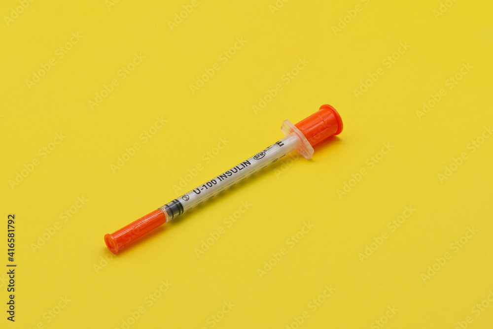 Insulin syringe on a yellow background