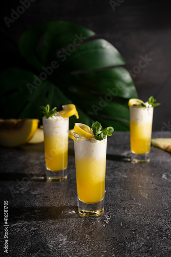 Photo for bar concept or magazines. Glasses of melon drink on dark background. Fresh and summer drink. laid out in layers with whipped cream
