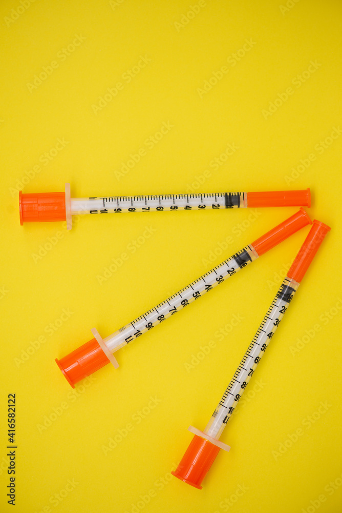 Fototapeta premium Insulin syringe on a yellow background