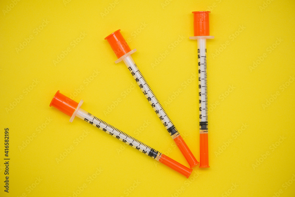 Insulin syringe on a yellow background