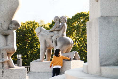 Photography Child playing among statues