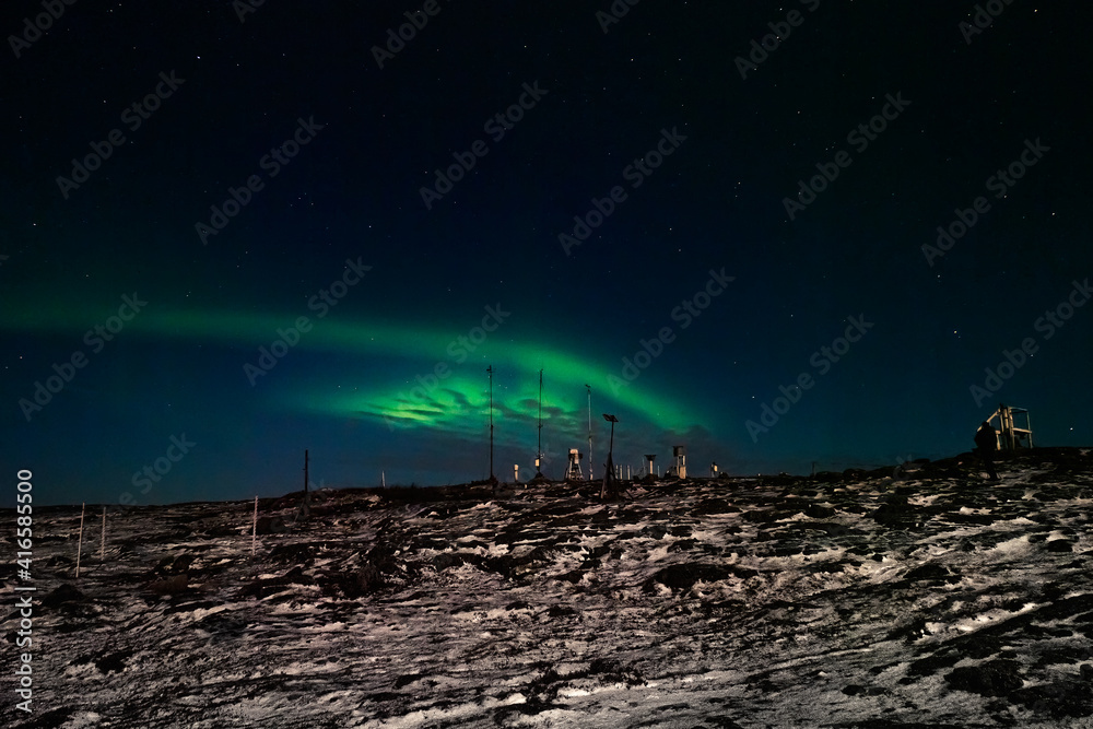 Old weather station. Night winter  polar landscape with the Aurora Borealis.