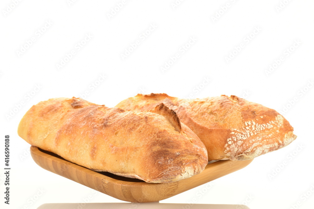 Two delicious freshly baked French baguettes on a bamboo plate, close-up, isolated on white.
