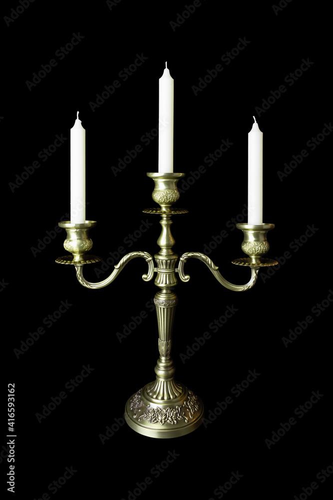 Triple bronze figurate candelabrum with three unlighted candles, isolated on black background