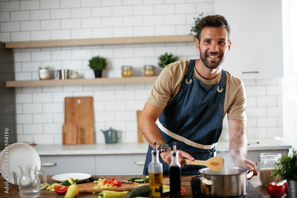 Handsome man preparing pasta in the kitchen. Guy cooking a tasty meal. Handsome man preparing pasta in the kitchen. Guy cooking a tasty meal.