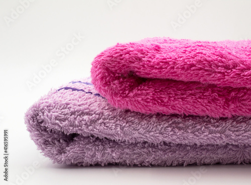 Pink and purple towels. They stand in the bathroom and are used to wipe hands and other parts of the body.