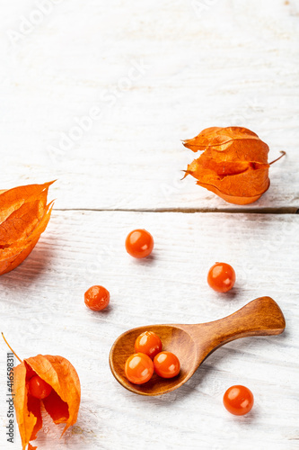 Physalis on wooden stump. Ripe berries of autumn red physalis fruit. berries fruit. Physalis or Chinese Lantern Plants. vertical image, place for text photo