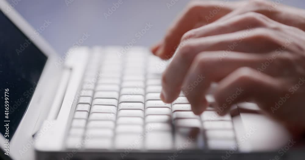 Close-up of male hands typing laptop keyboard