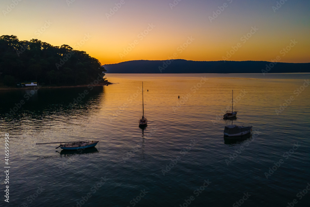 Boats at rest and gentle sunrise over the bay