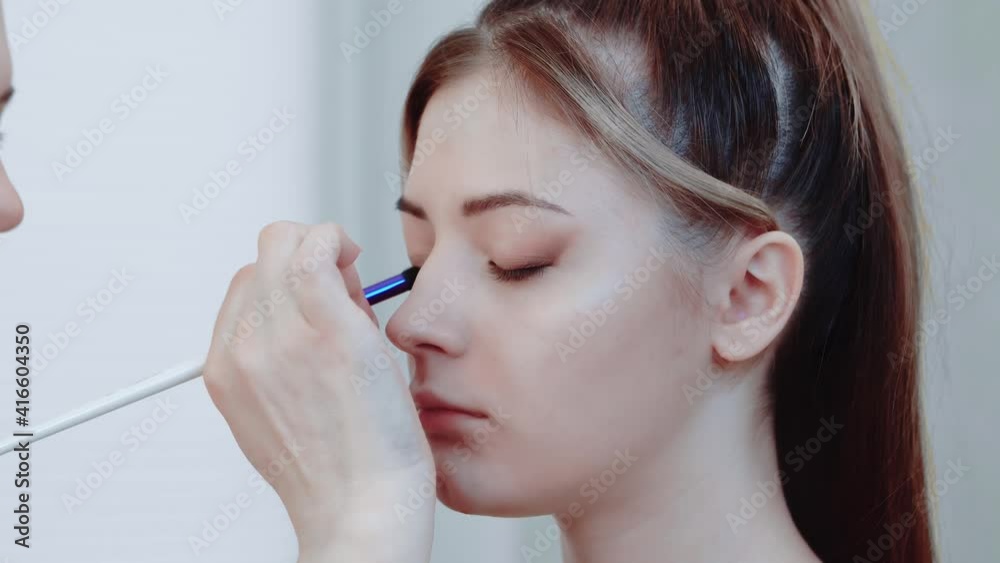 Professional makeup with a model. Make-ups of eyelids and eyelashes. Makeup artist makes stylish makeup to a young woman, makeup for beauty. Makeup artist work Professional makeup with a model. Make-ups of eyelids and eyelashes. Makeup artist makes stylish makeup to a young woman, makeup for beauty. Makeup artist work