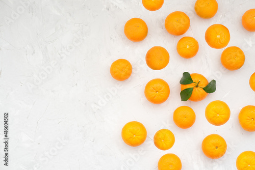 Tangerines on white background. Good harvest of ripe and large tangerines has been harvested. To improve health and replenish the body with vitamins, you can prepare wonderful fresh juice. Close-up