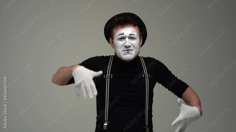 Middle shot portrait of suffering male mime slowly raises hands to face, in pain and crying. Talented actor wearing hat and gloves showing pantomime on white background. Shooting in slow motion. Middle shot portrait of suffering male mime slowly raises hands to face, in pain and crying. Talented actor wearing hat and gloves showing pantomime on white background. Shooting in slow motion.