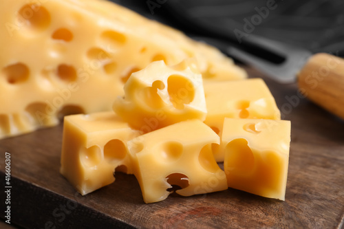 Pieces of delicious cheese on wooden board, closeup