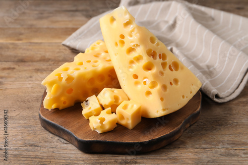 Pieces of delicious cheese on wooden table