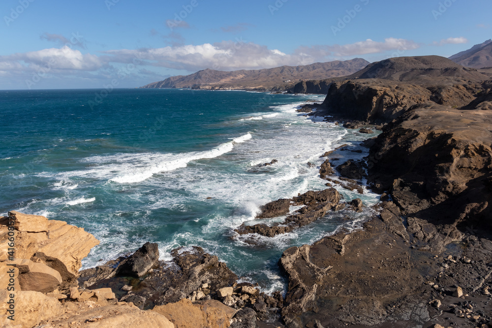 Ocean view on la Pared beach. Beautiful view of the clear sea, waves, cliffs and beach in Playa de la Pared - Canary Islands, Fuerteventura, Spain. 