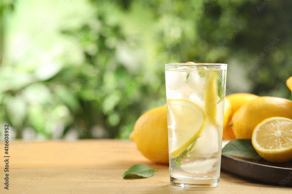 Fototapeta premium Cool freshly made lemonade and fruits on wooden table. Space for text