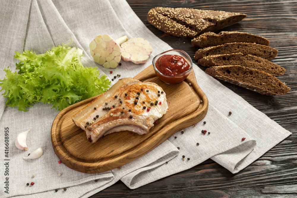Fried pork entrecote on a board for serving.