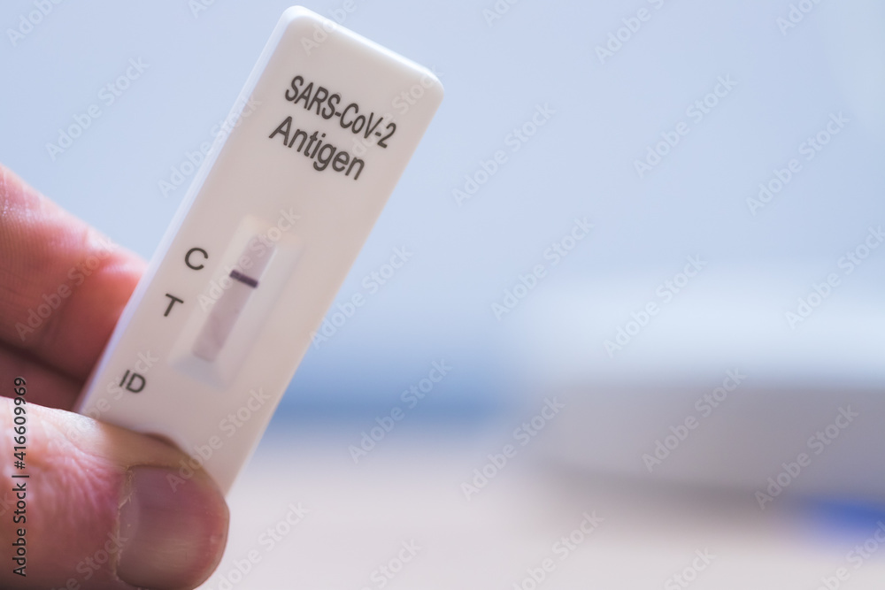 Express corona test at home: Close up of fingers holding a negative covid antigen test Express corona test at home: Close up of fingers holding a negative covid antigen test