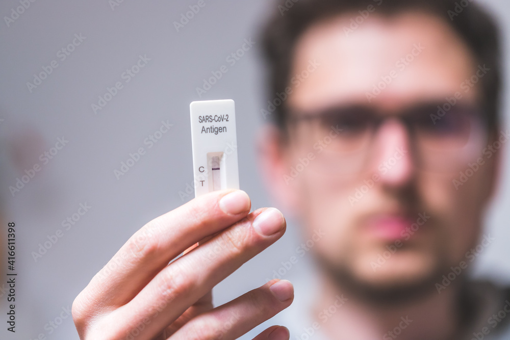 Express corona test at home Close up of young man holding a negative