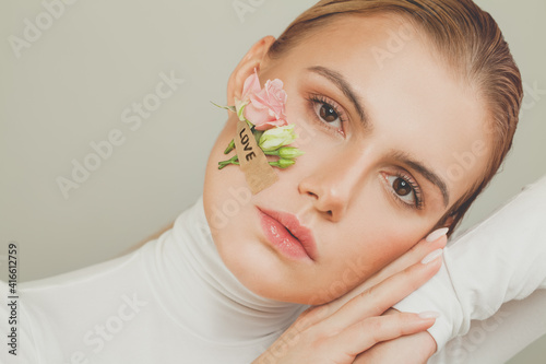 Nice woman with flowers and Love inscription on white background portrait