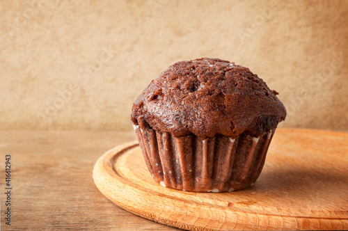 Chocolate muffin on a wooden table. Fresh bakery.