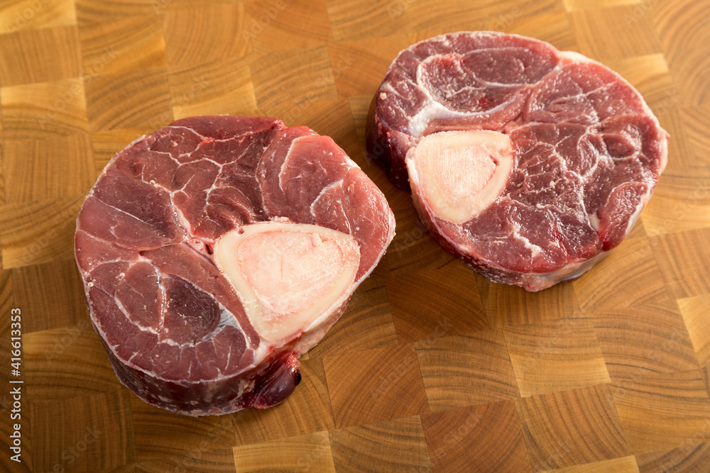 Raw piece of beef with herbs on a cutting board.