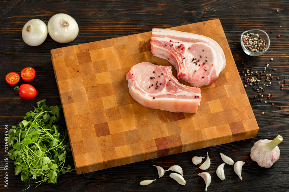 Raw pork entrecote on a board for serving.
