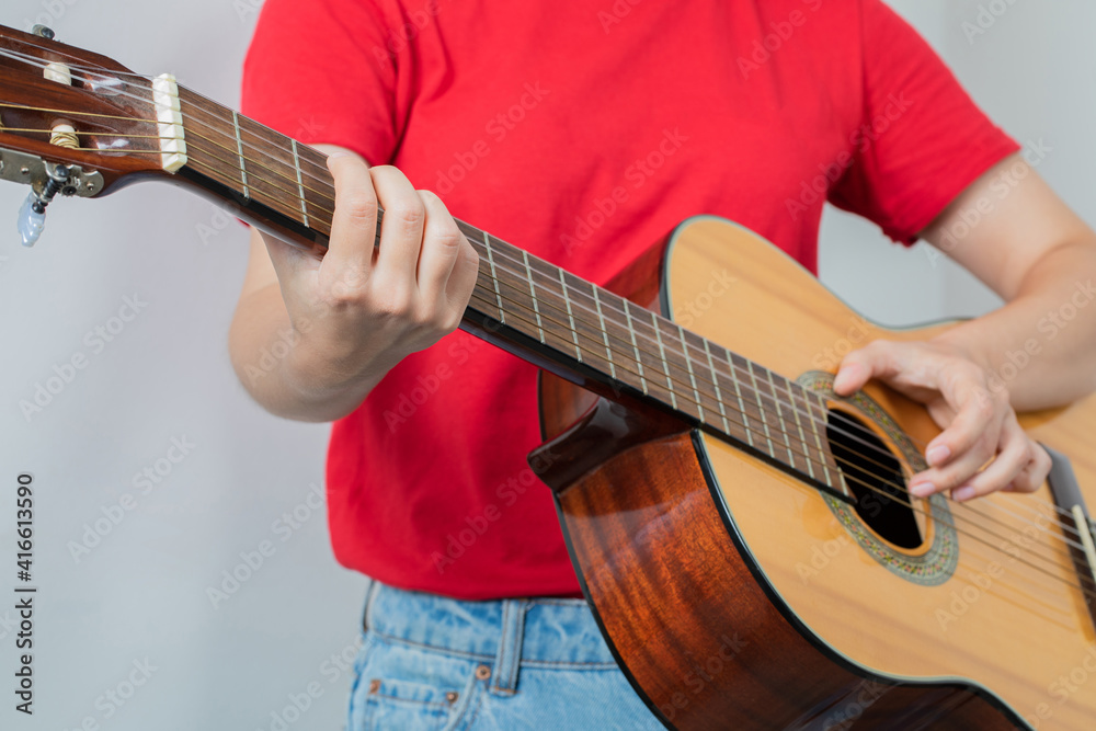 Fototapeta premium Female model holding a wooden guitar