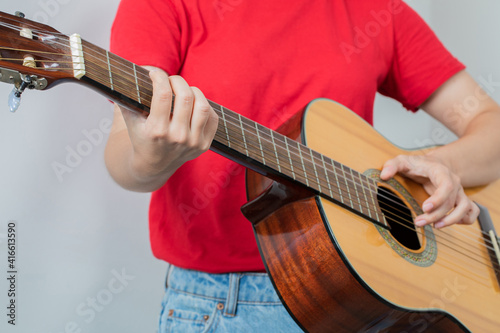 Female model holding a wooden guitar