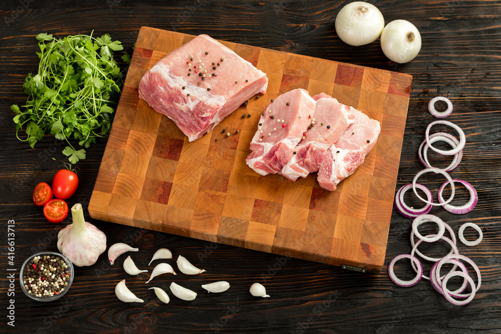 Raw pork entrecote on a board for serving.