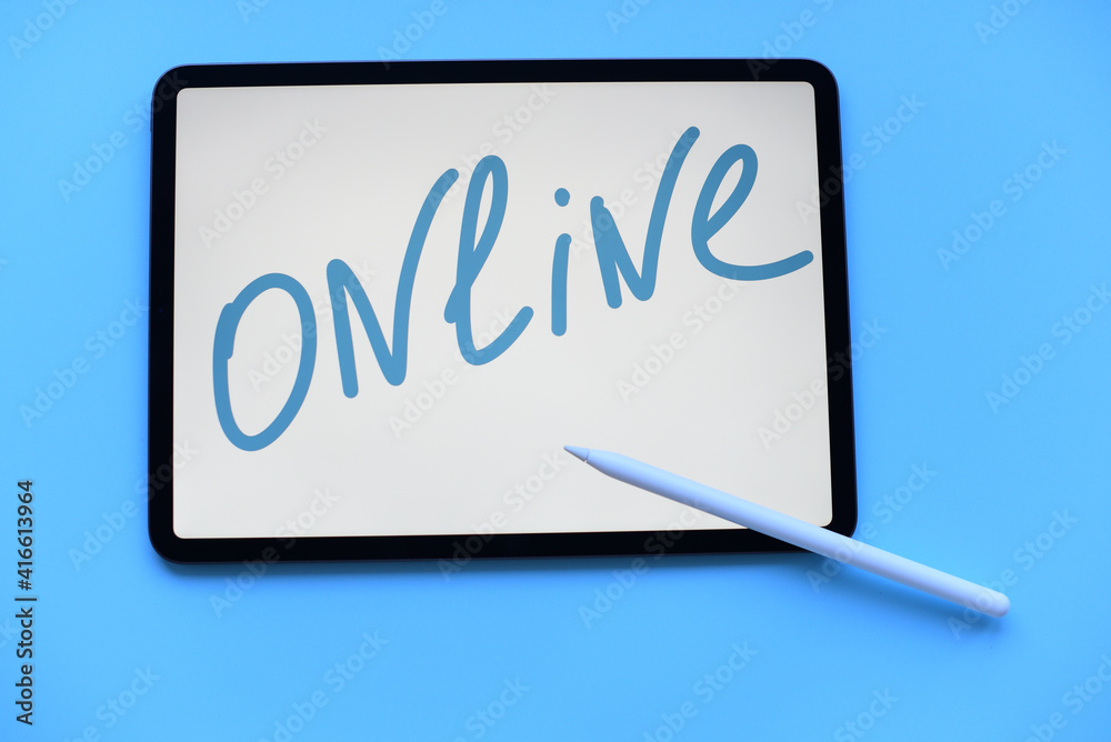 Tablet with inscription online with Pencil and air pods on blue background Tablet with inscription online with Pencil and air pods on blue background