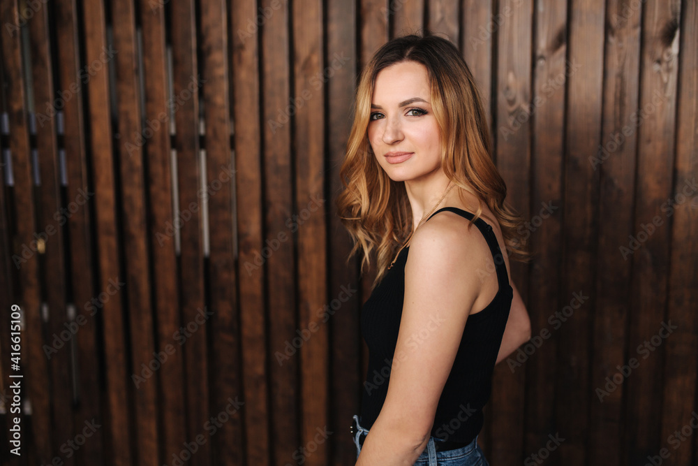 Fototapeta premium Fashion model in denim and black t-shirt in studio. Happy attractive female smile
