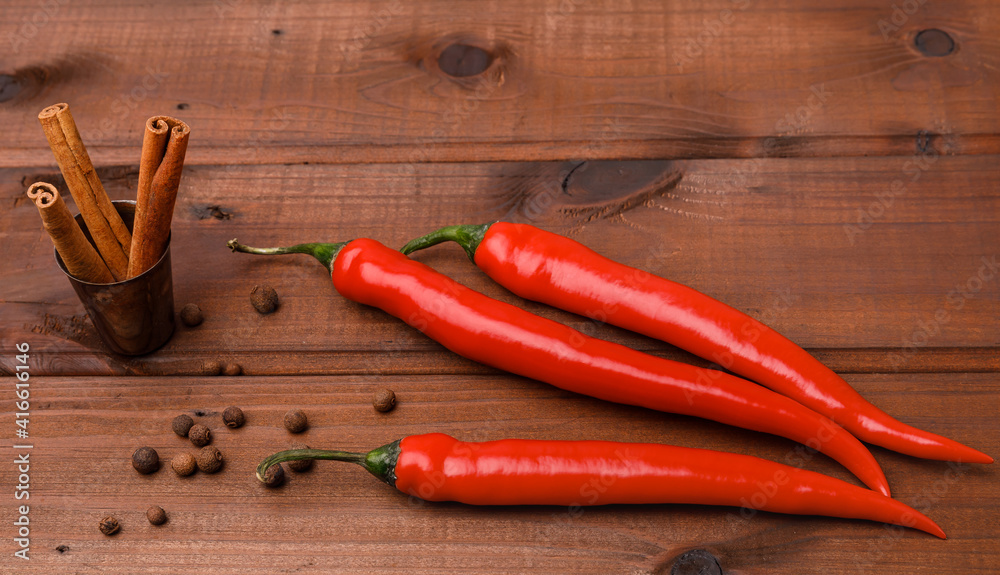 Red chili peppers and spice on a wooden surface Red chili peppers and spice on a wooden surface