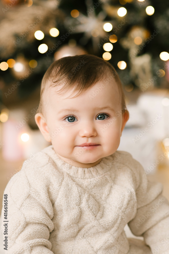 Little cute baby girl under the Christmas tree. Happy Holidays, Happy New Year. Christmas Time Little cute baby girl under the Christmas tree. Happy Holidays, Happy New Year. Christmas Time